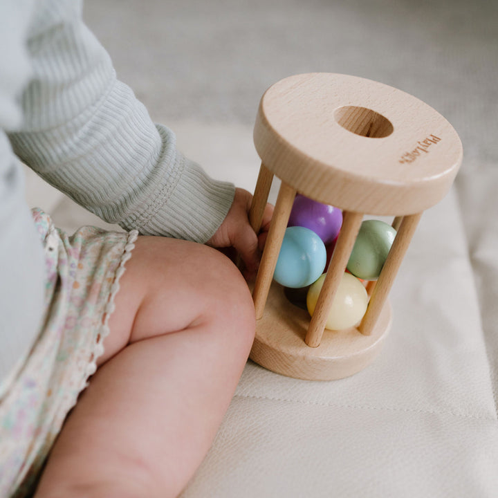 Wooden rolling rattle to promote crawling in 6-12 month olds